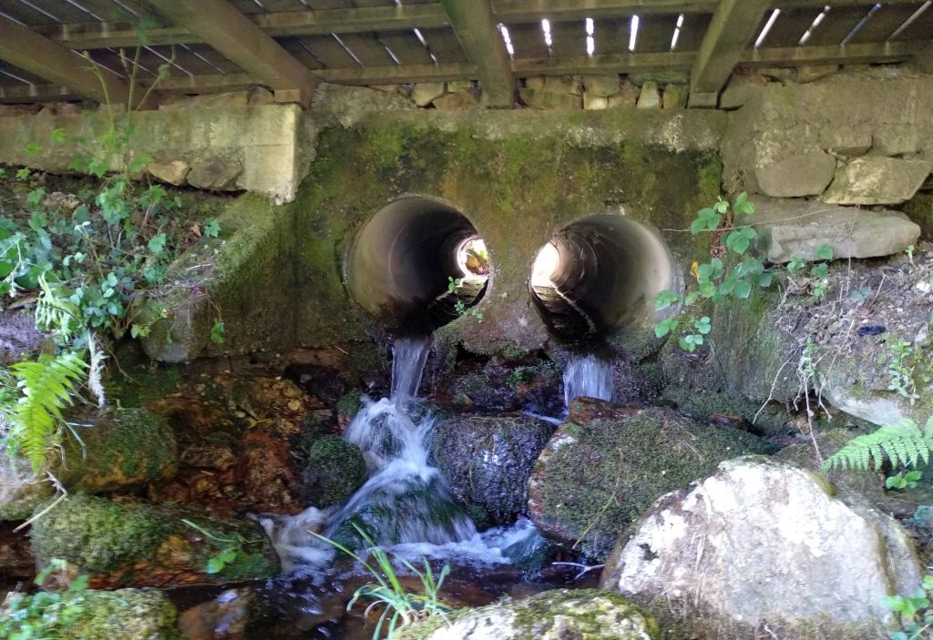 Vista del cauce del río Miño bajo la carretera de acceso a la zona recreativa de la Cruz de Meira. Al otro lado de la carretera, el agua emerge a la vista bajo los últimos bloques del Pedregal.